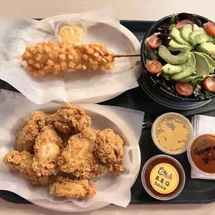 Korean fried chicken, potato corn dog, and avocado salad with ginger dressing