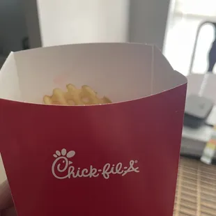 ows a hand holding a box of macaroni and cheese