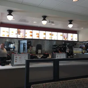 ows a man standing at a counter in a fast food restaurant