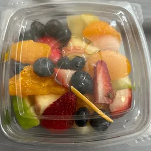 ows a plastic container filled with fruit