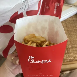 ows a person holding a box of fries