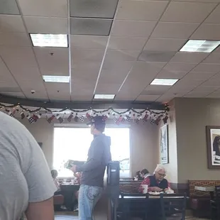 ows a man standing in a restaurant