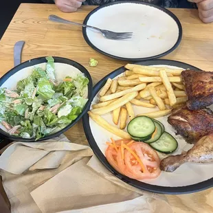 Half chicken dark with salad and fries.