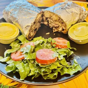 Brasa Burrito with salad and green and yellow sauce