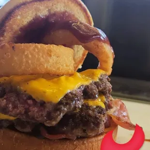 a burger with onion rings and bacon