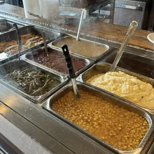 Clockwise display of green beans, gravies, jus, mashed potatoes, and corn