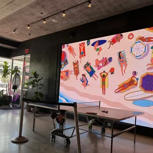 people playing ping - pong on a large screen