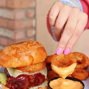 a person putting sauce on a sandwich