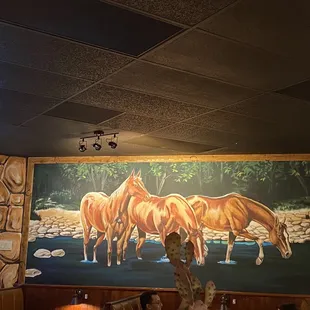a mural of horses in a restaurant