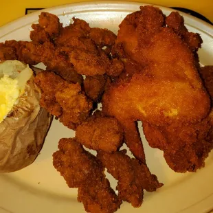 a plate of fried chicken and a baked potato