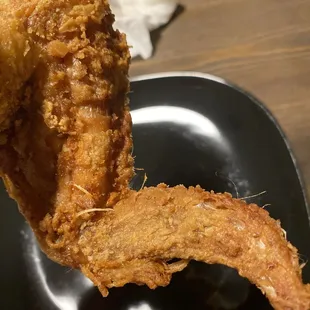 a fried chicken on a black plate