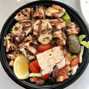 Chicken Souvlaki Platter with fresh lemon slice and Greek salad