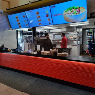 a restaurant counter with a large screen