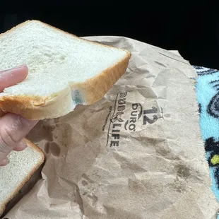 a hand holding a piece of bread