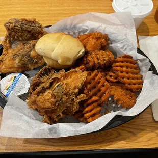 Two chicken breast plate with sweet potato fries and creamy cole slaw and yeast roll.