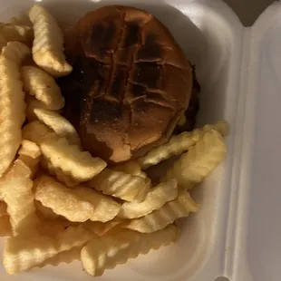 a sandwich and french fries in a styrofoam container