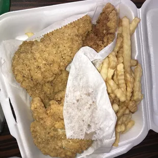 fried chicken and french fries in a styrofoam container