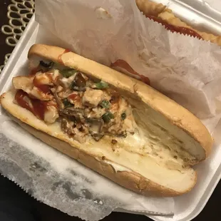 a hot dog in a styrofoam container