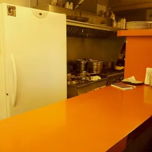a kitchen with orange counter tops