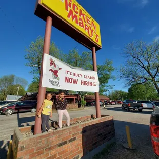 two people standing in front of a sign