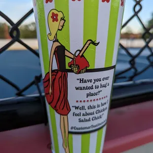 a paper cup with a picture of a woman in a red dress