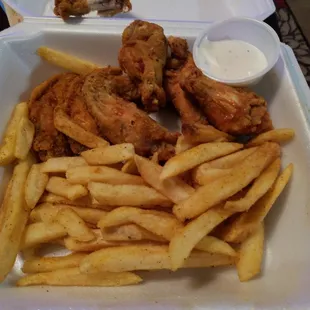 chicken wings and fries in a styrofoam container