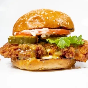 a chicken sandwich with lettuce, tomato, and pickles