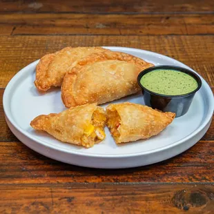 a plate of empanadas with dipping sauce