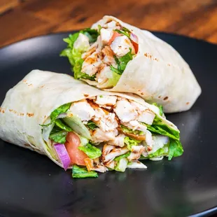 two burritos on a black plate