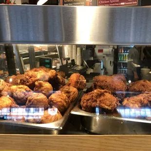 a variety of fried chicken in a display case