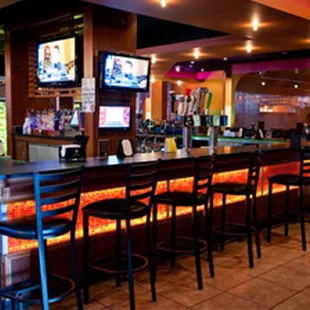 a bar with a bar stool and televisions