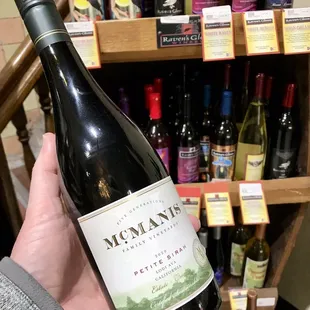 a hand holding a bottle of wine