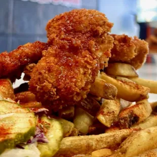 a pile of fried chicken and french fries