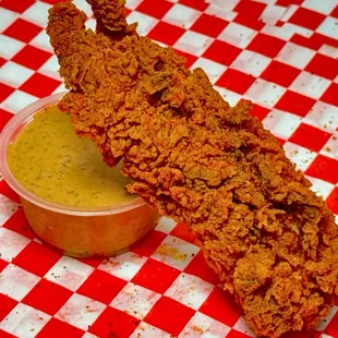 a fried chicken skewer with mustard