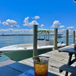 a drink on a table with a boat in the background