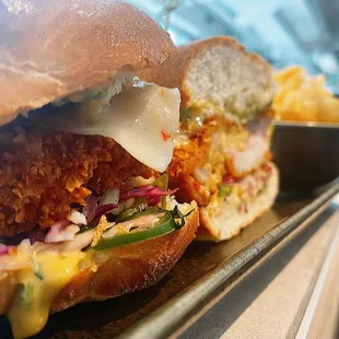 a chicken sandwich with cheese and pickles
