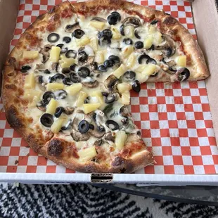 Pineapple pizza with mushrooms, black, olives, and spinach... light cheese