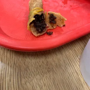 a half eaten taco on a red plate