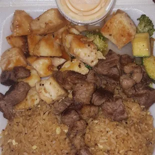 Steak and chicken with fried rice, yum yum sauce, and habichi veggies