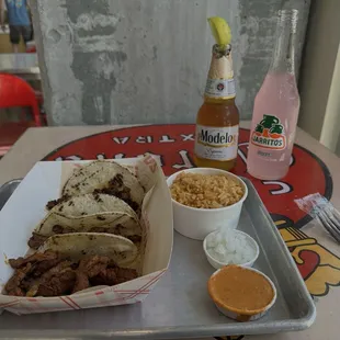 Street tacos with a side of rice a modelo and jarritos