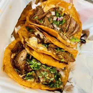three beef tacos in a styrofoam container