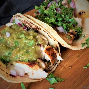 a close up of a chicken taco with guacamole