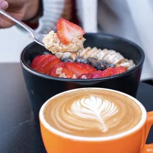 a cup of coffee and a bowl of fruit