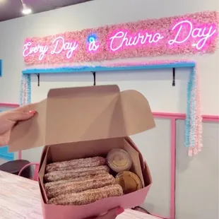 a person holding a box of churros