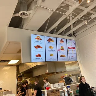 a restaurant counter with a menu on the wall