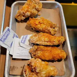 a tray of fried chicken wings and rice