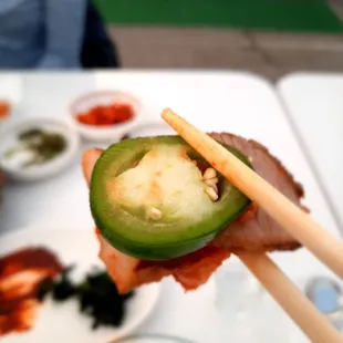 chopsticks holding a jalapeno pepper