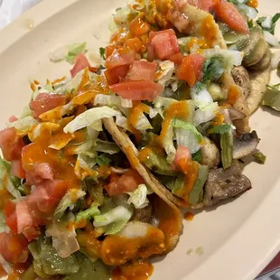 Cactus, mushroom, and pumpkin flower tacos, topped with lettuce, tomato, onion, cilantro, and salsa