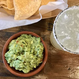 Guacamole alongside chips and a margarita