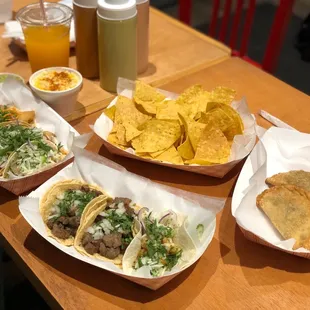 Steak tacos, shrimp taco, fish taco, empanadas, chips, and guacamole